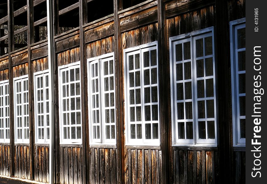 Row of old windows in a old wood plank building. Row of old windows in a old wood plank building.