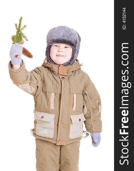 A smiling boy dressed for winter with a branch of fur tree with cones. A smiling boy dressed for winter with a branch of fur tree with cones