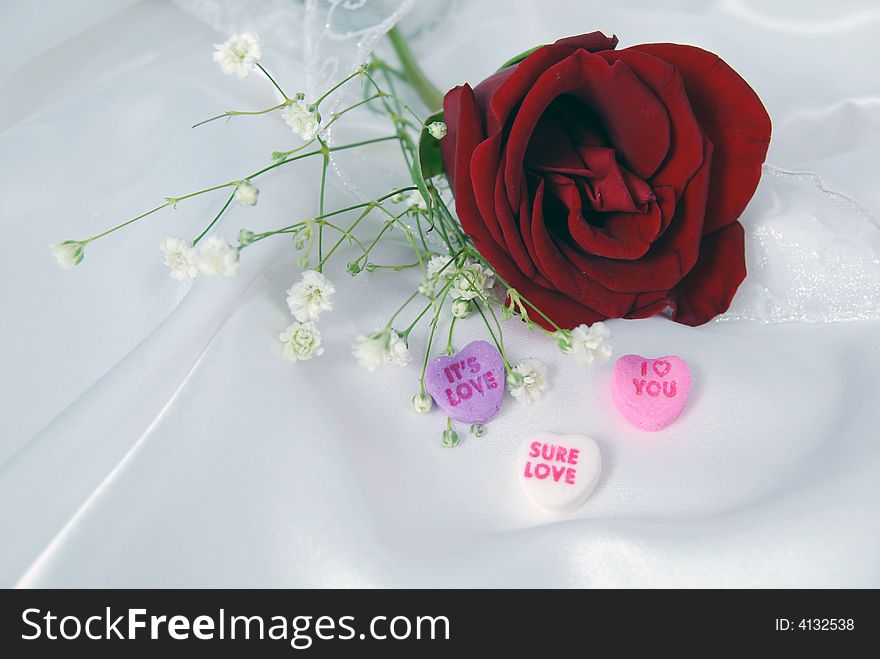 Red rose on satin with valentine candy. Red rose on satin with valentine candy.