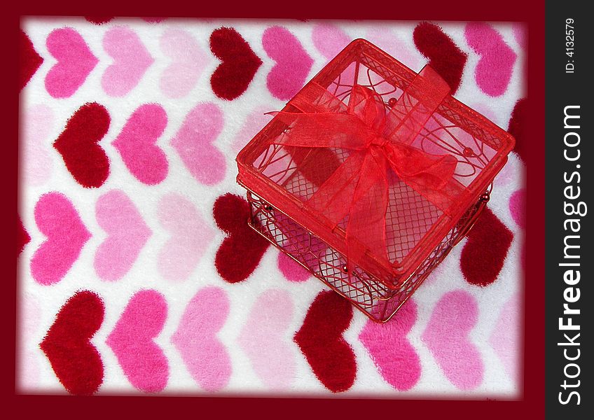 A red wire box with a bow on a fuzzy heart background with a dark red border. A red wire box with a bow on a fuzzy heart background with a dark red border.