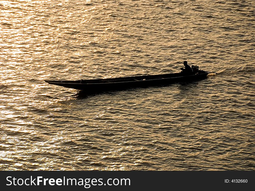 Small riverboat silhouette on a river