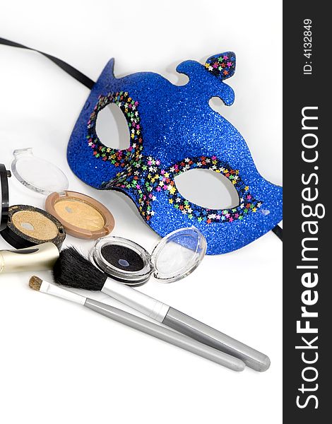 Blue carnival mask and gold eyeshadows with brush on white. Blue carnival mask and gold eyeshadows with brush on white