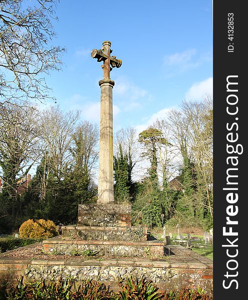 Tall Stone Cross in an English Cemetery against a Blue Winters sky