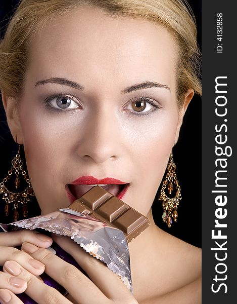 A beautiful young woman eating a slab of chocolate. A beautiful young woman eating a slab of chocolate