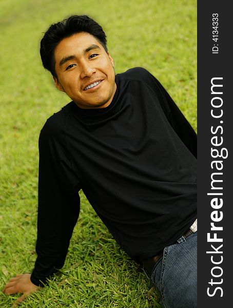 Portrait of a smiling man sit back on a grass. Portrait of a smiling man sit back on a grass