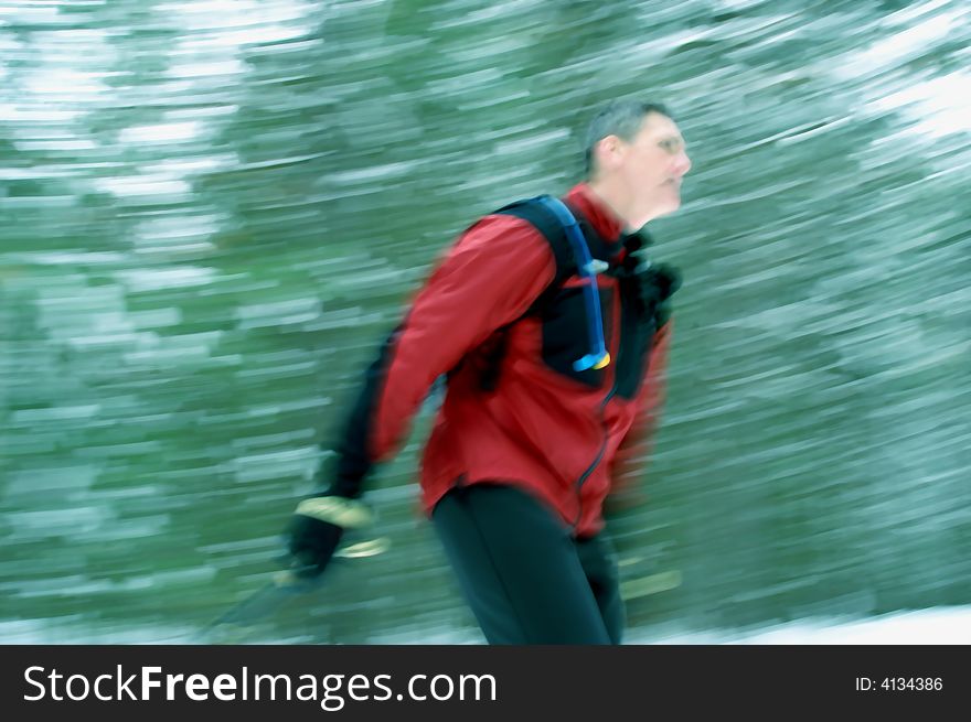 Nordic skate-skier blazes through coniferous forest in central Ontario. Nordic skate-skier blazes through coniferous forest in central Ontario.