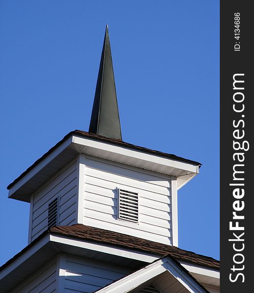 Pointed church steeple against blue sky. Pointed church steeple against blue sky.