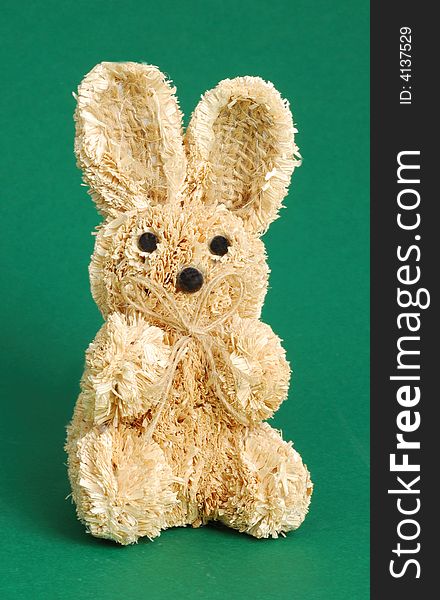 Easter straw rabbit on green background