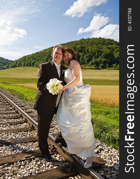 Bridal couple on rails, being in the nature. Great azure sky. Great summer!. Bridal couple on rails, being in the nature. Great azure sky. Great summer!