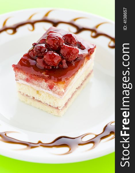 Piece of raspberry cake on the plate with chocolate dressing