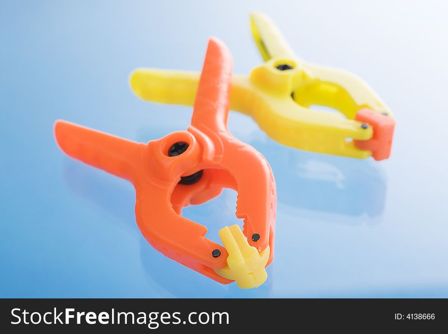 Plastic clamps over a blue reflective background