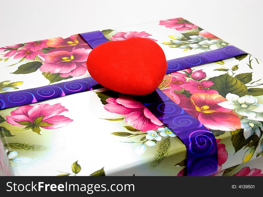 Red velvet heart lays on a gift box. Red velvet heart lays on a gift box
