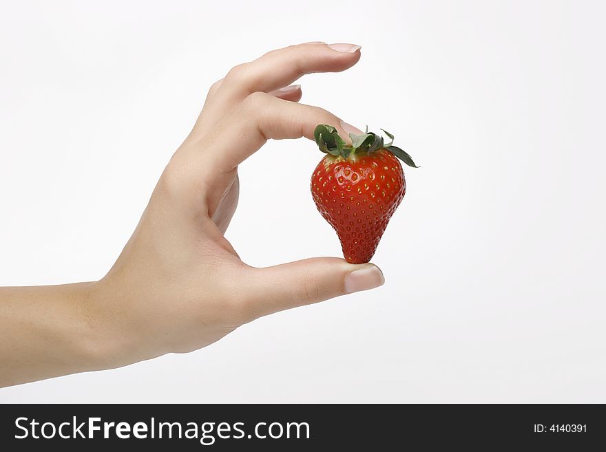 Closeup shot of one strawberry in womans fingers. Closeup shot of one strawberry in womans fingers