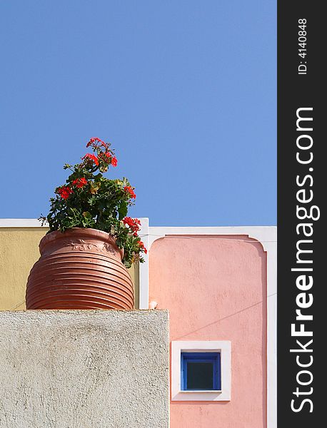 Flower-pot with pelargonium and small window in Santorini in Greece