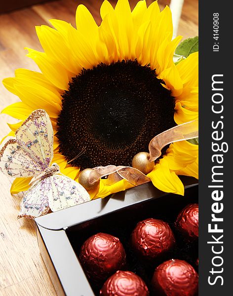 Sunflower, butterfly and chocolate balls in a box