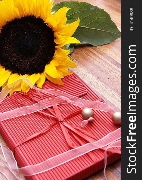 Sunflower, butterfly and a red box on a wooden table