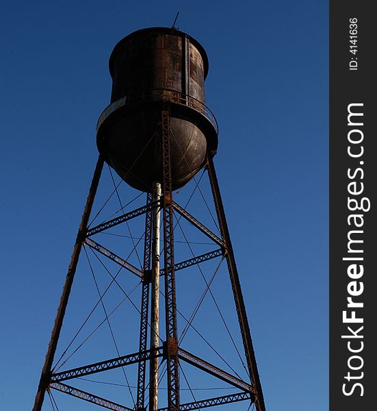 Old rusted water tower against a blue sky. Old rusted water tower against a blue sky