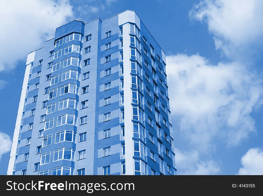 Modern city building against sky. Blue colored image.
