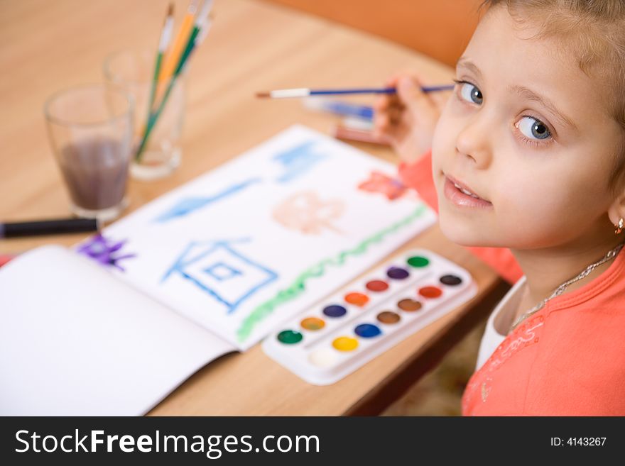 Pretty caucasian girl watercolor paint and look in camera. Close-up. Pretty caucasian girl watercolor paint and look in camera. Close-up