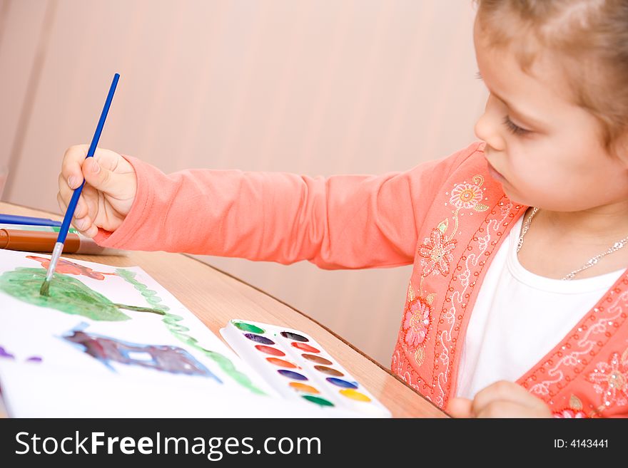 Pretty caucasian child watercolor paint . Focus point on a hand.
