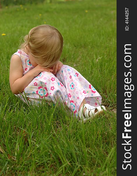 A preschool girl in a dress looking sad. A preschool girl in a dress looking sad.