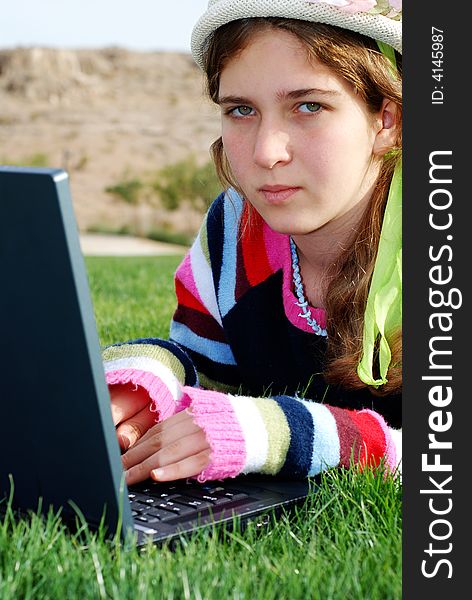 Young girl is working on laptop at outdoor location. Young girl is working on laptop at outdoor location