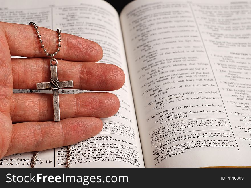 Holy bible open with a cross on a hand. Holy bible open with a cross on a hand