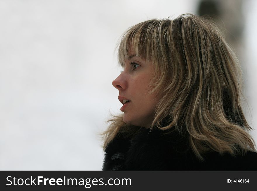 Portrait of the young smiling woman in the winter