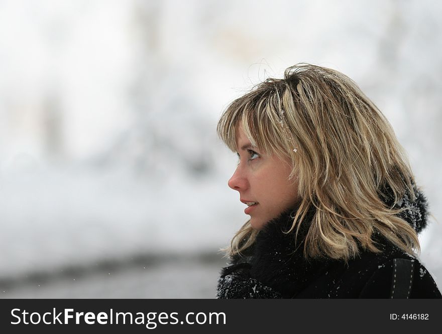 Portrait of the young smiling woman in the winter