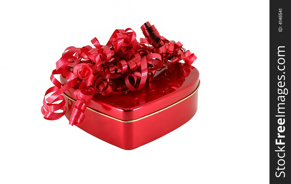 A red heart shaped box with a pile of curly red ribbons on top for Valentine's day. A red heart shaped box with a pile of curly red ribbons on top for Valentine's day.