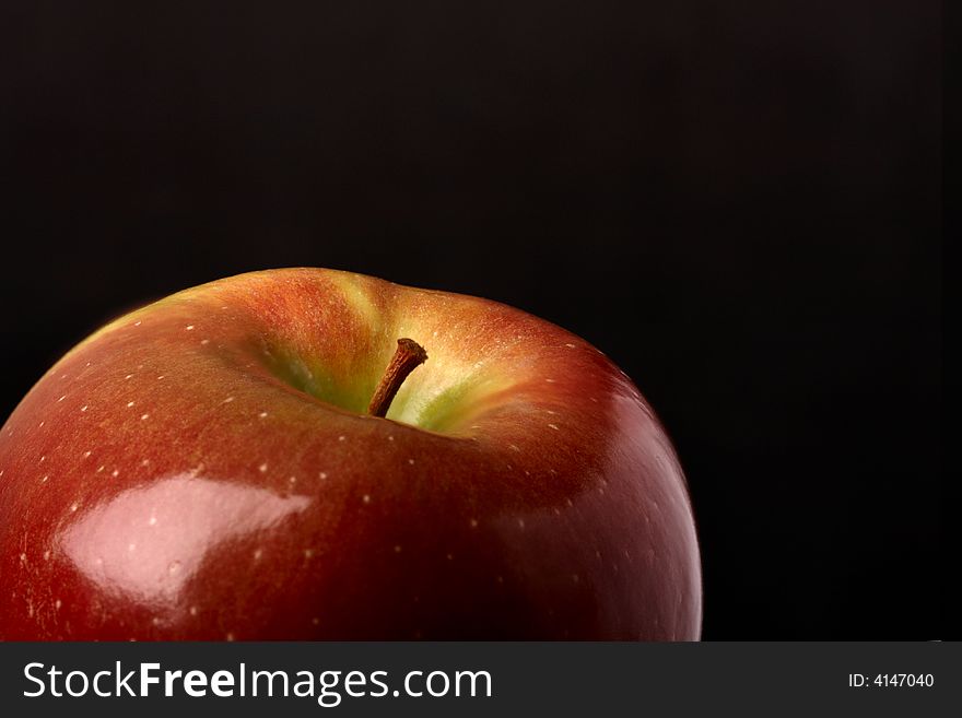 The top part of a juicy apple in a darkness. The top part of a juicy apple in a darkness