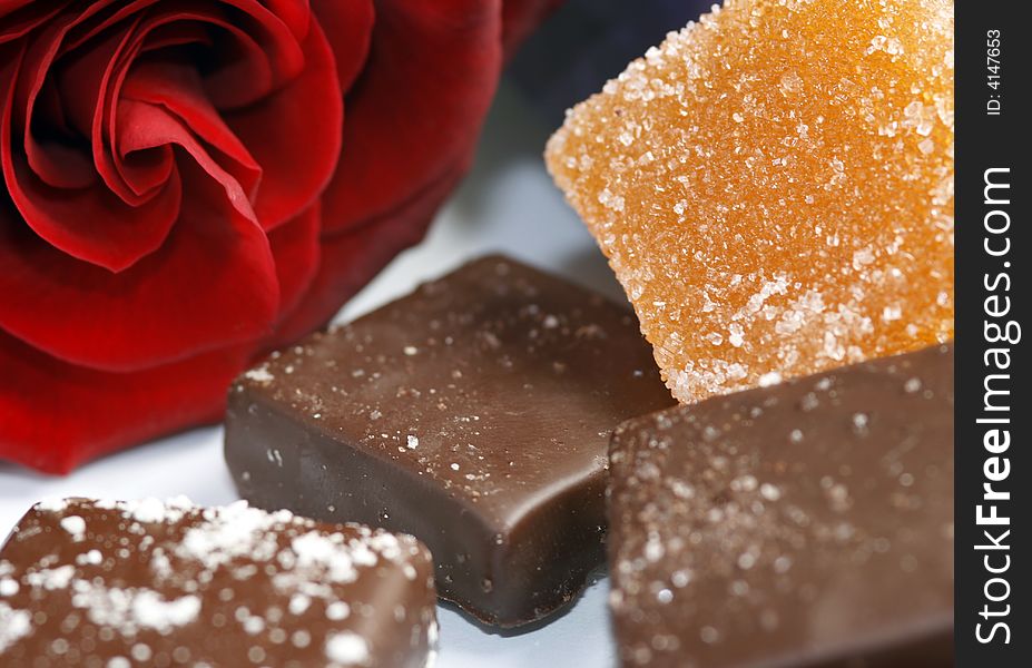 3 chocolate sweets with marmalade and red rose. 3 chocolate sweets with marmalade and red rose