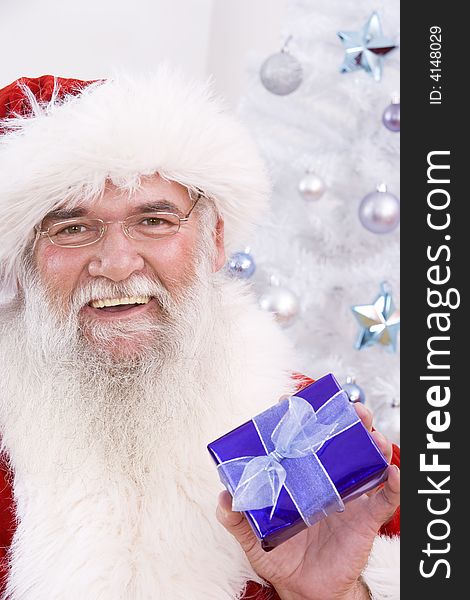 Santa laughing and holding a small special gift. Santa laughing and holding a small special gift