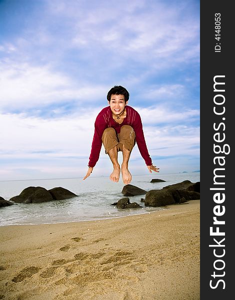 Man jumping up high with excitement by the beach with evening sky. Man jumping up high with excitement by the beach with evening sky