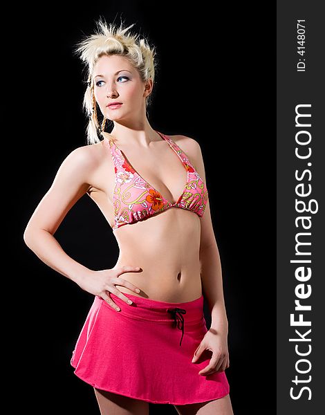 Blond Caucasian woman in bikini top and pink skirt look one side. Blond Caucasian woman in bikini top and pink skirt look one side