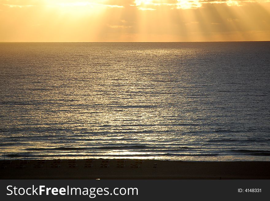 Sunset and with sun loungers in sand