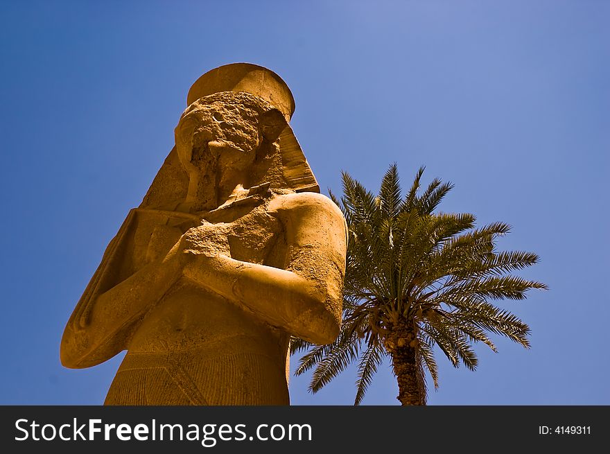 Statue of Egyptian Pharaoh with a palm tree