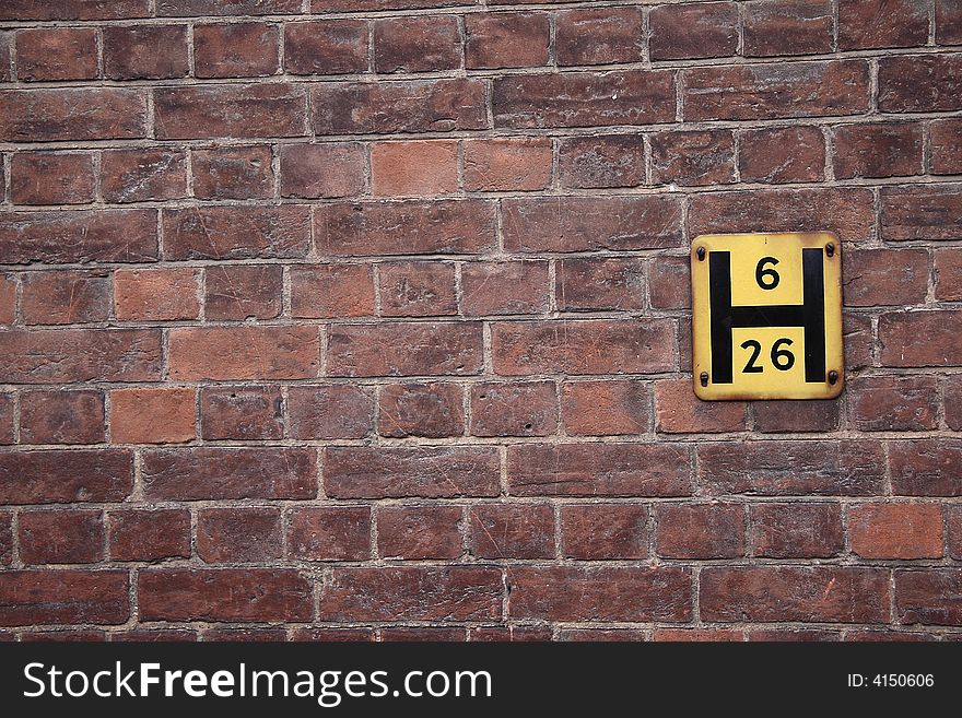 Red brick wall with yellow hydrant sign