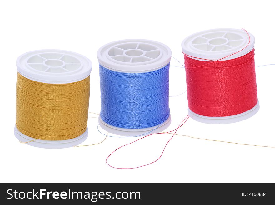 Three plastic spools of colored yarn. Three plastic spools of colored yarn