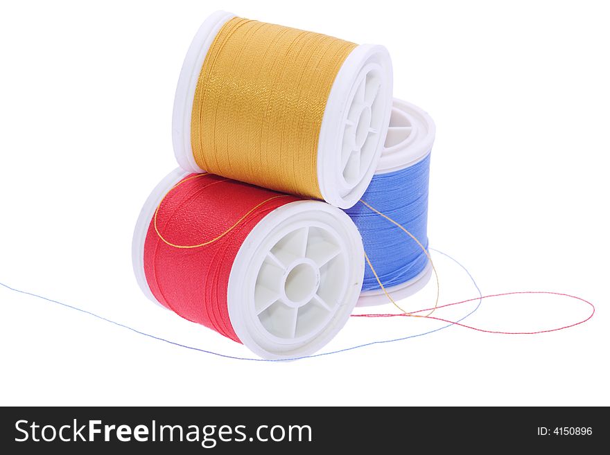 Three colored thread reels on white. Three colored thread reels on white