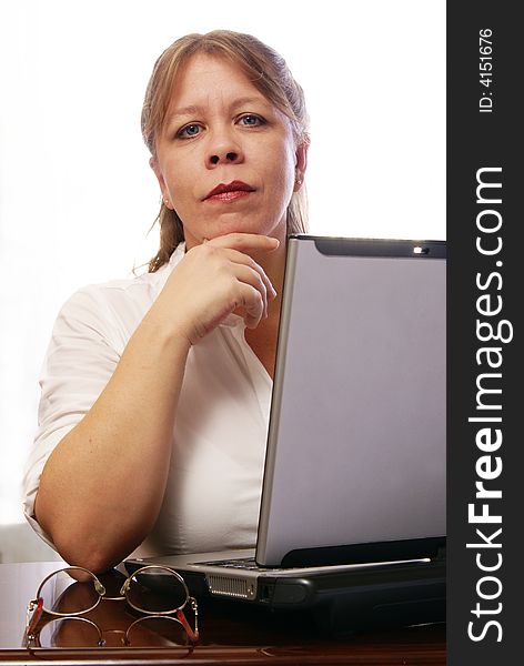 Woman in white blouse working on laptop computer. Woman in white blouse working on laptop computer