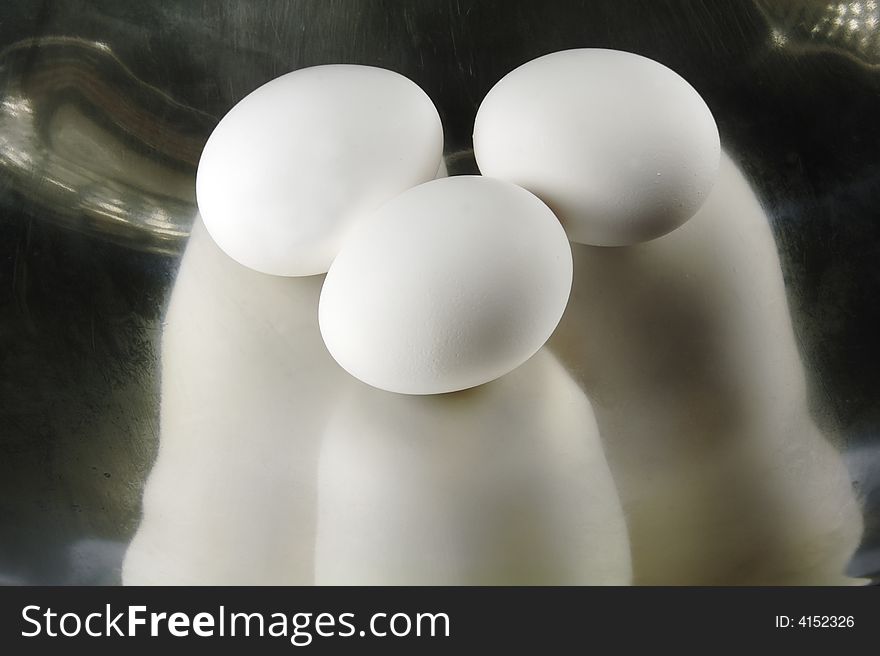 Three Eggs reflecting in a Metal Dish. Three Eggs reflecting in a Metal Dish.