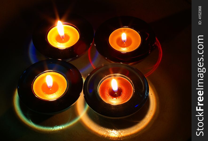 Four colored candles in glass bowls. Four colored candles in glass bowls