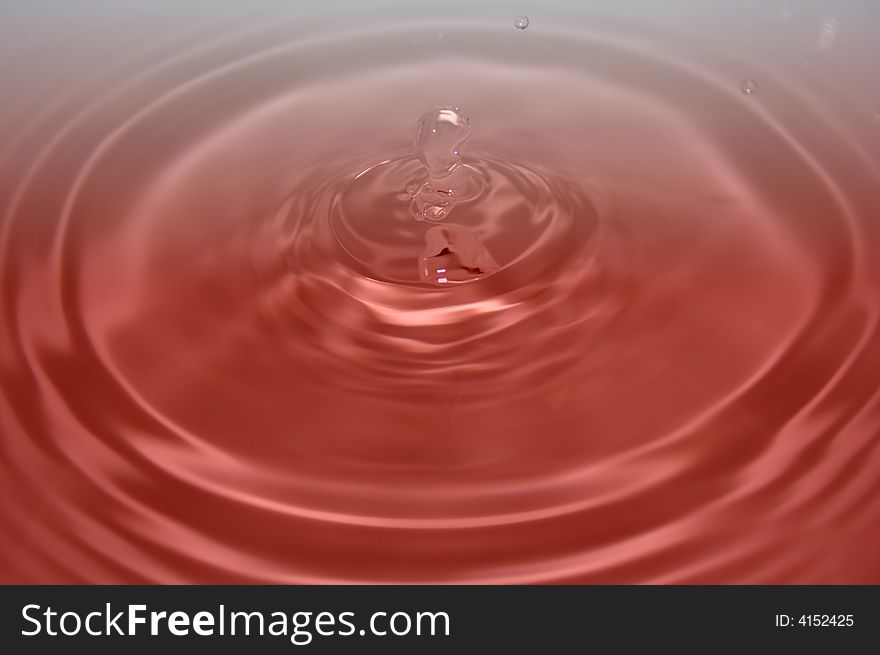 Water drop on gradient white and red background.