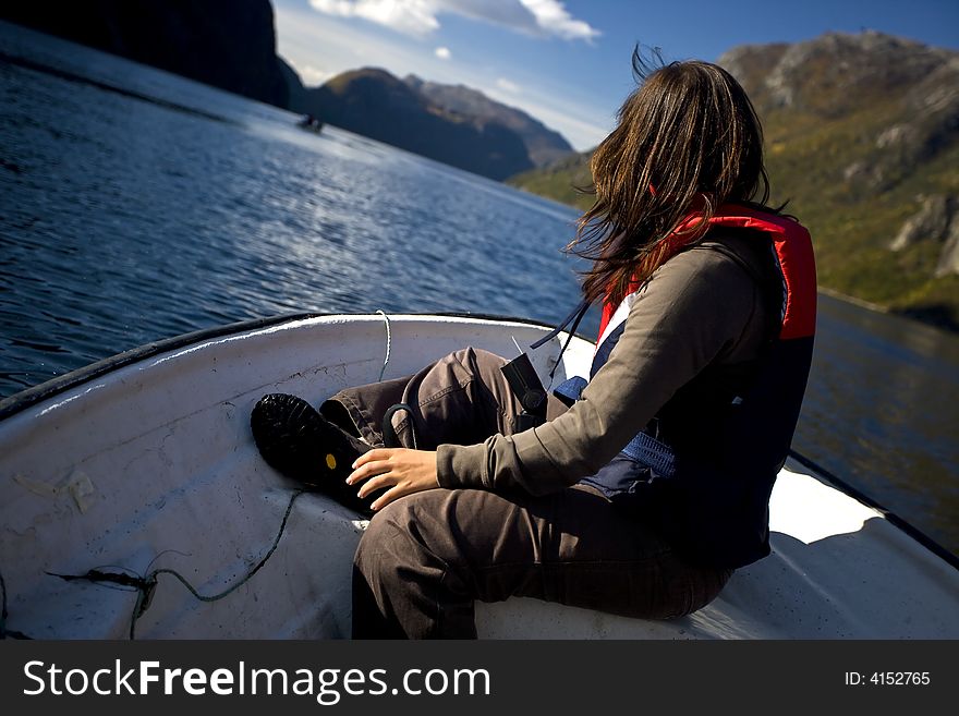 Young woman inside small white boat - image tilted for extra dinamism. Young woman inside small white boat - image tilted for extra dinamism