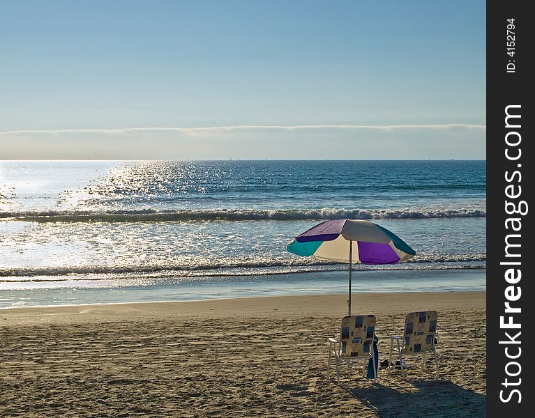 Two chairs and umbrella on a sandy ocean beach. Two chairs and umbrella on a sandy ocean beach