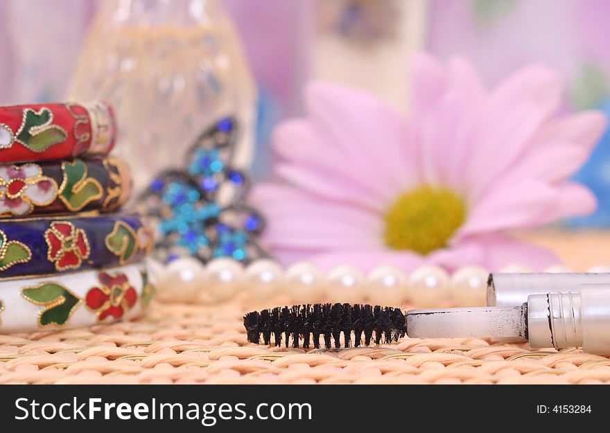 Jewelry and Mascara With Flower on Wicker  Vanity. Jewelry and Mascara With Flower on Wicker  Vanity
