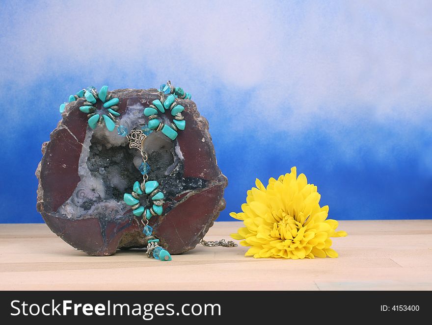 Necklace on Geode With Flower on Blue Textured Background