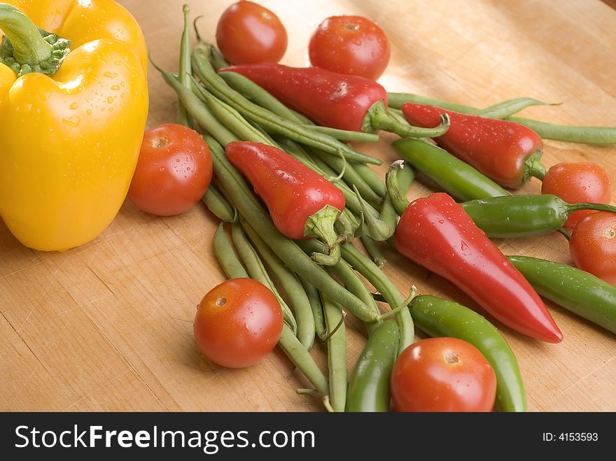 A group of fresh sunlit vegetables on a wooden cutting board