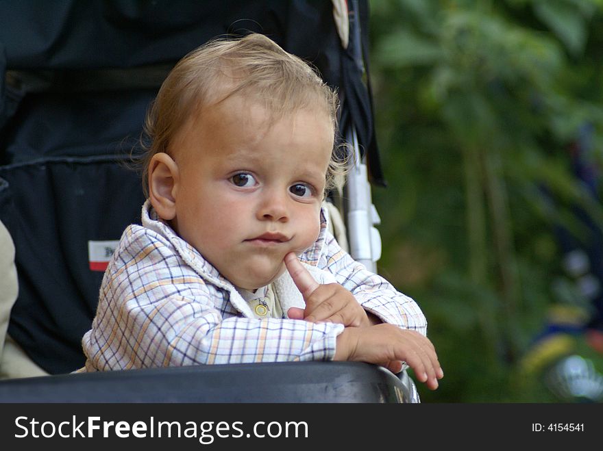 Child thinking while sitting in carriage. Child thinking while sitting in carriage